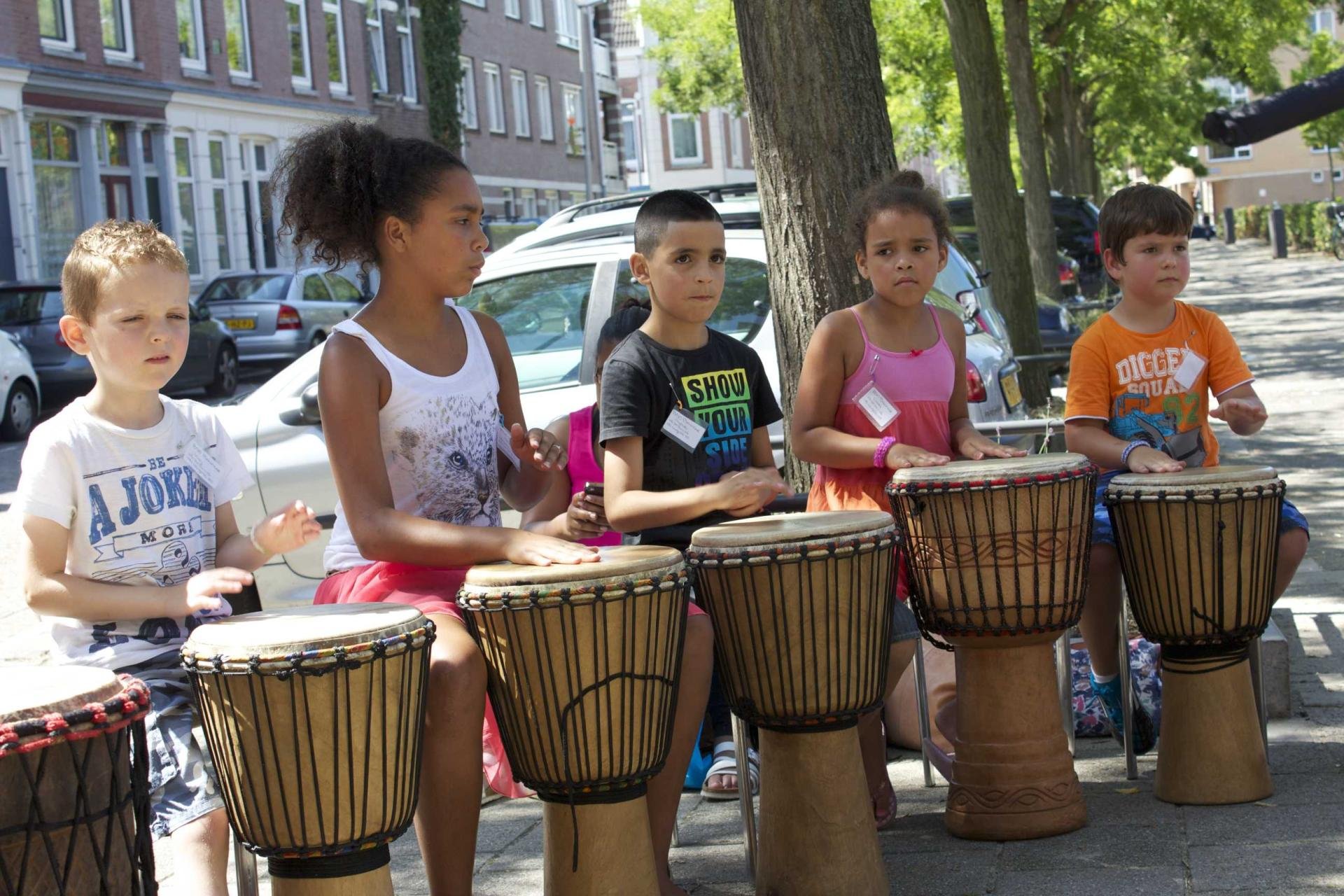Vijf kinderen maken muziek met djembés