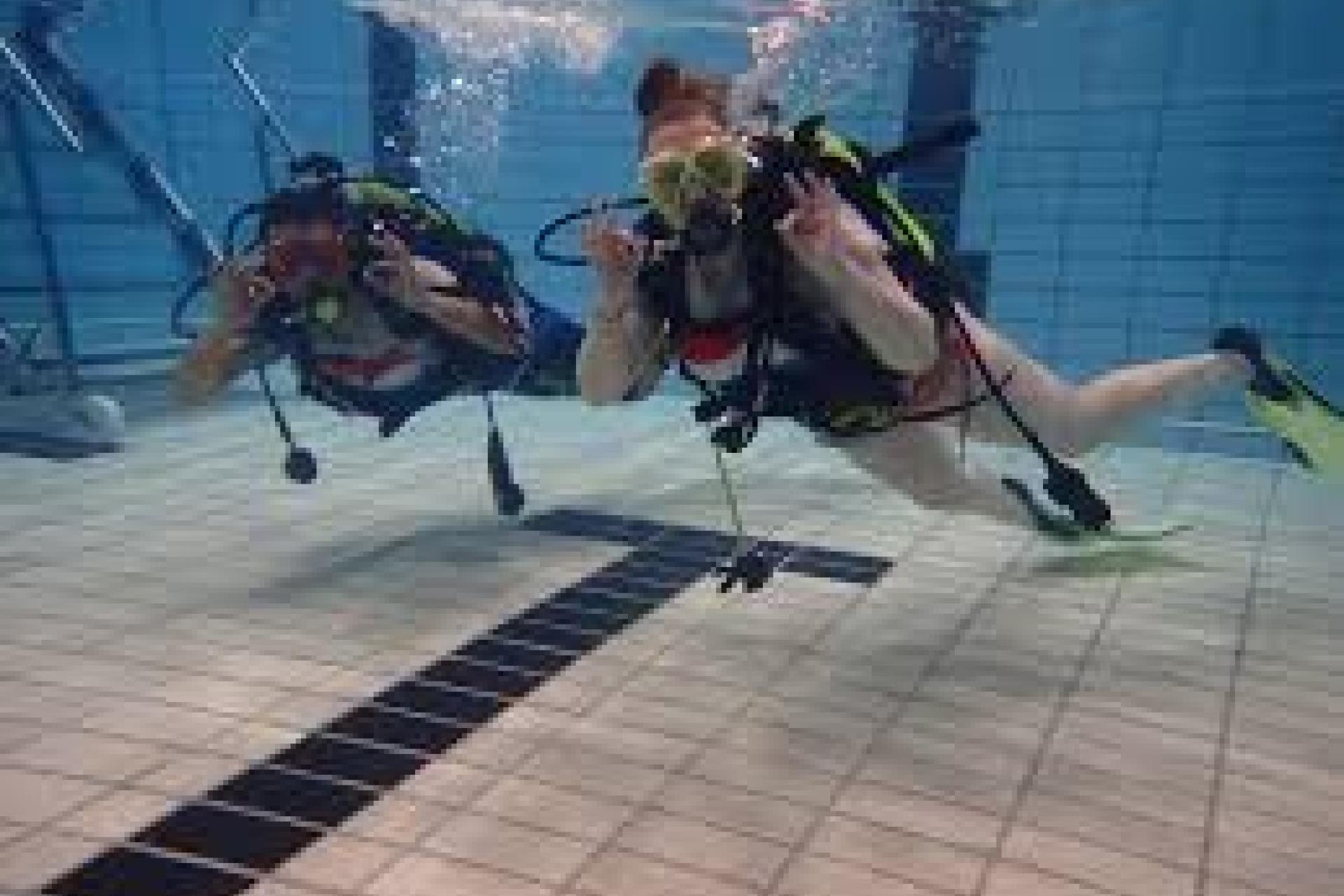 2 duikers in het zwembad met het oké signaal