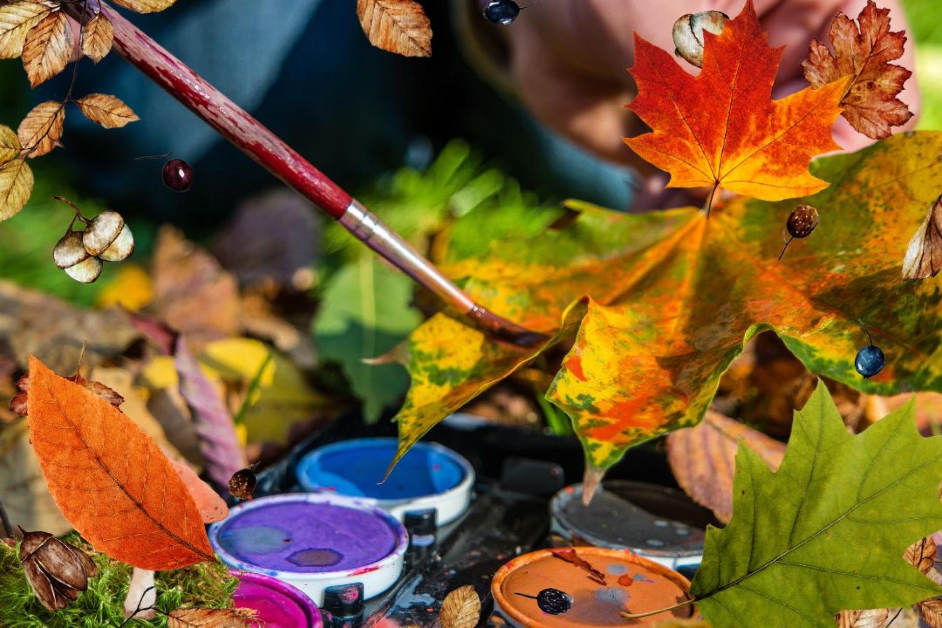 Een kwast schildert op herfstbladeren