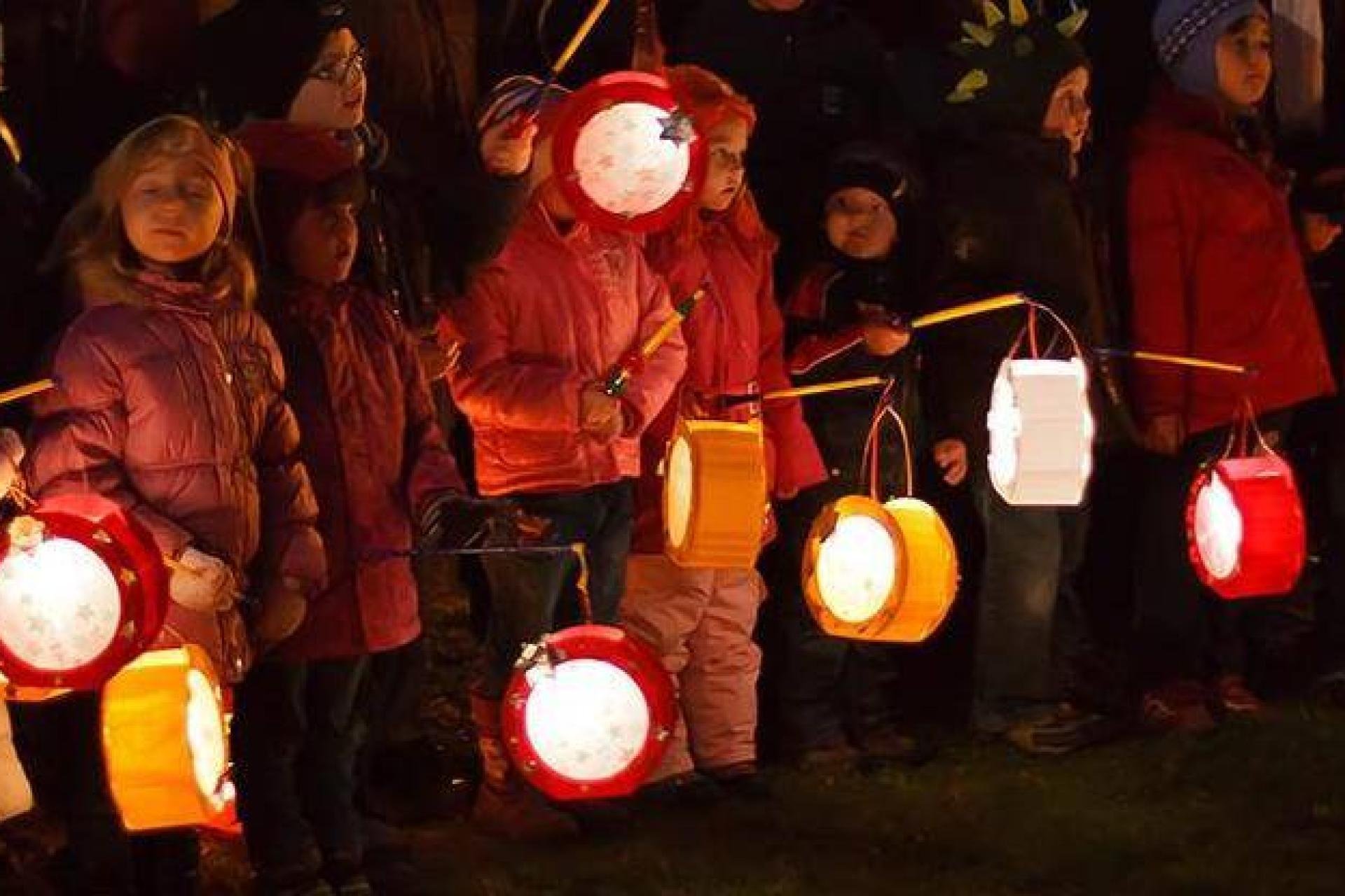 kinderen lopen in het donker met een lampion