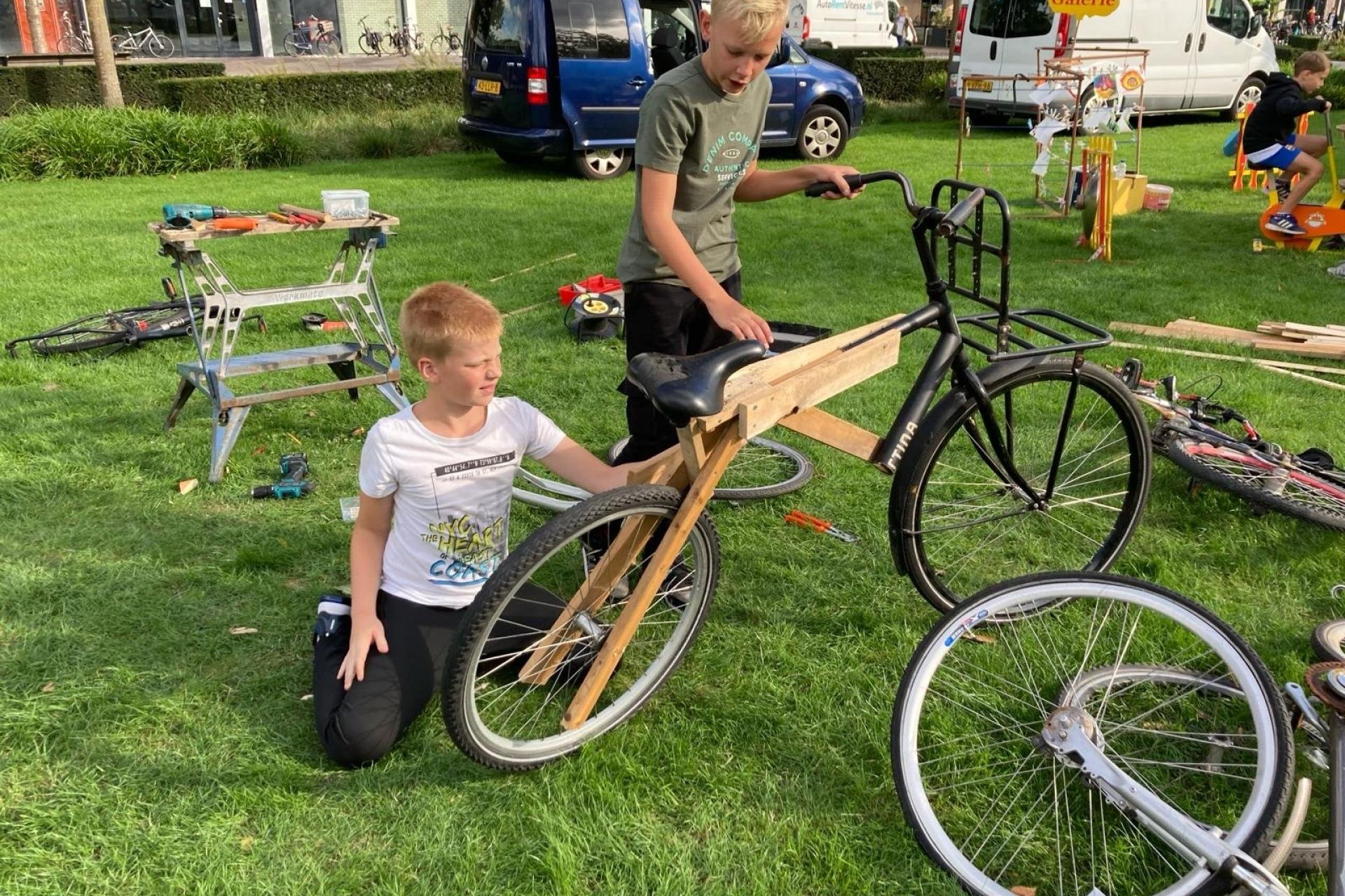 jongens bouwen bike van hout en fietsonderdelen