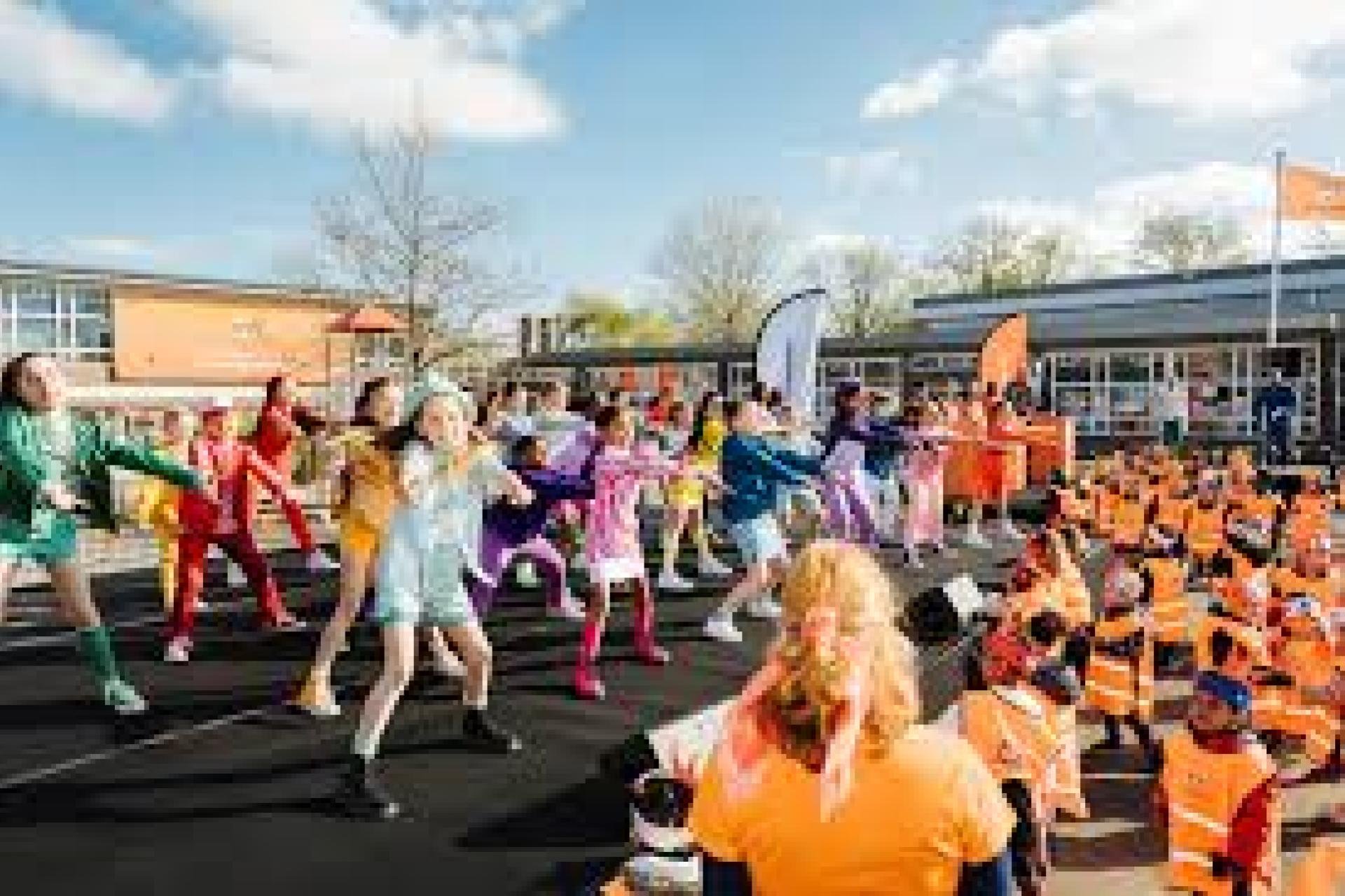 Een plein vol met oranje geklede dansers en danseressen